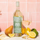 Mom Juice Pinot Grigio on pink tile background with lemon, lime and pear